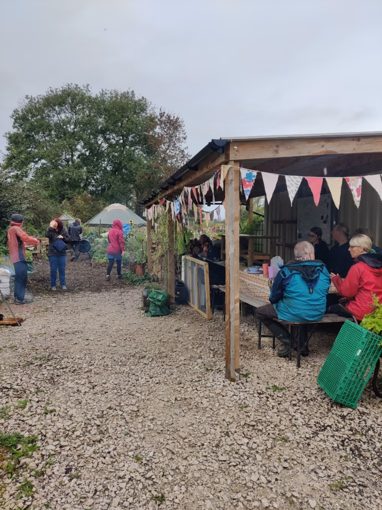 volunteers sharing lunch at a table in a community garden